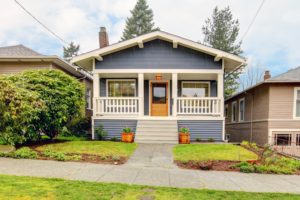 12760946 - small simple blue grey craftsman style house with white porch.
