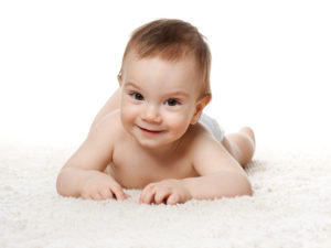 13024624 - a baby boy is lying on the carpet; isolated on the white background