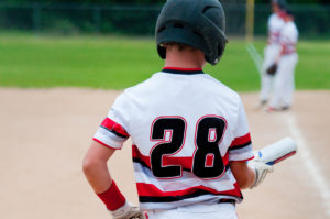 Close up of Baseball kid looking down at bat.